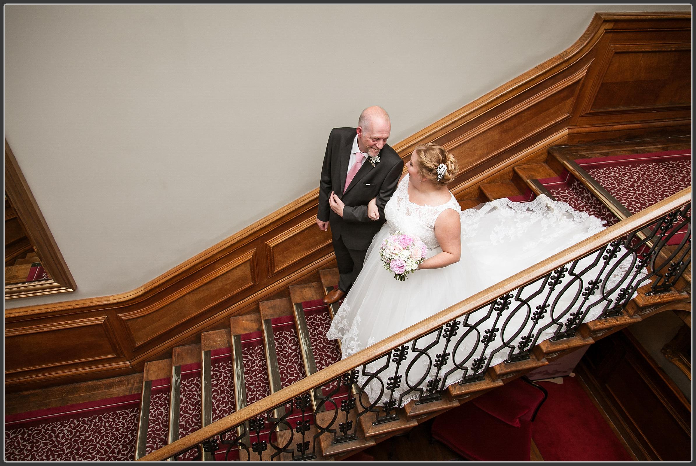 Bride and her father walking down the stairs