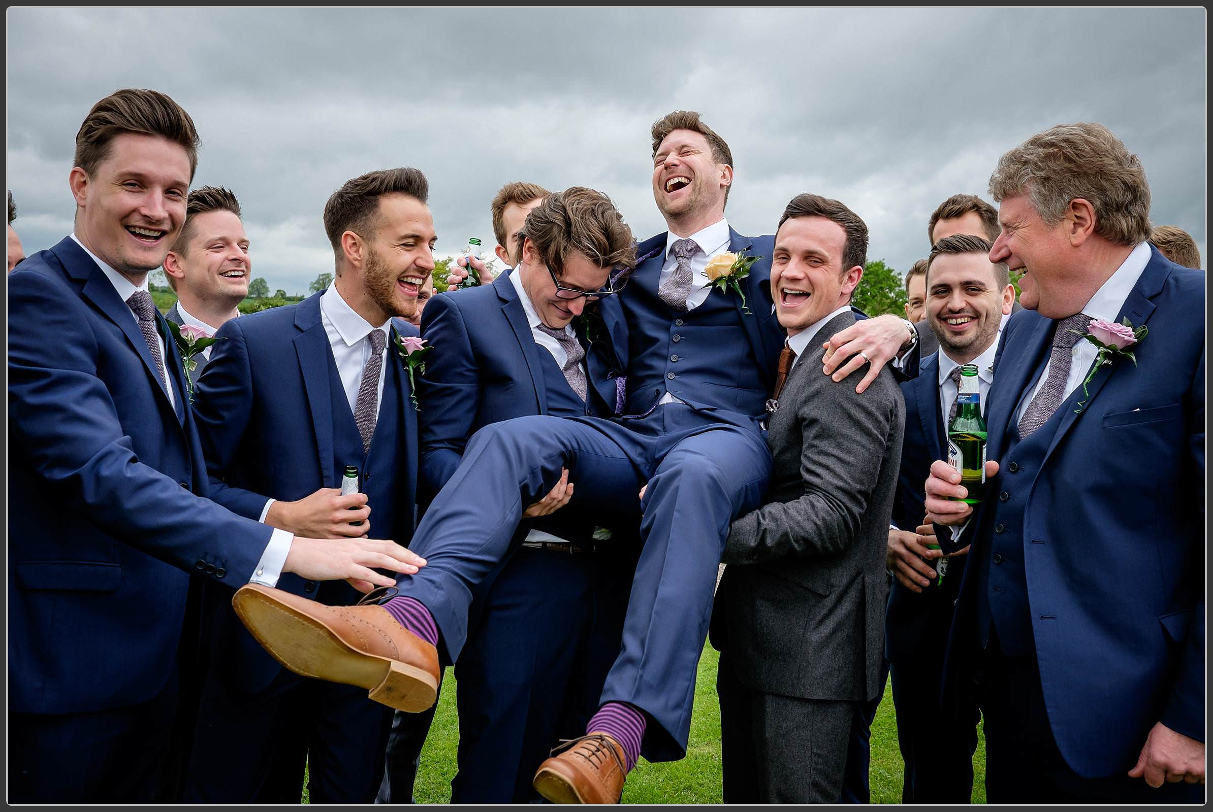 The groomsmen picking up the groom