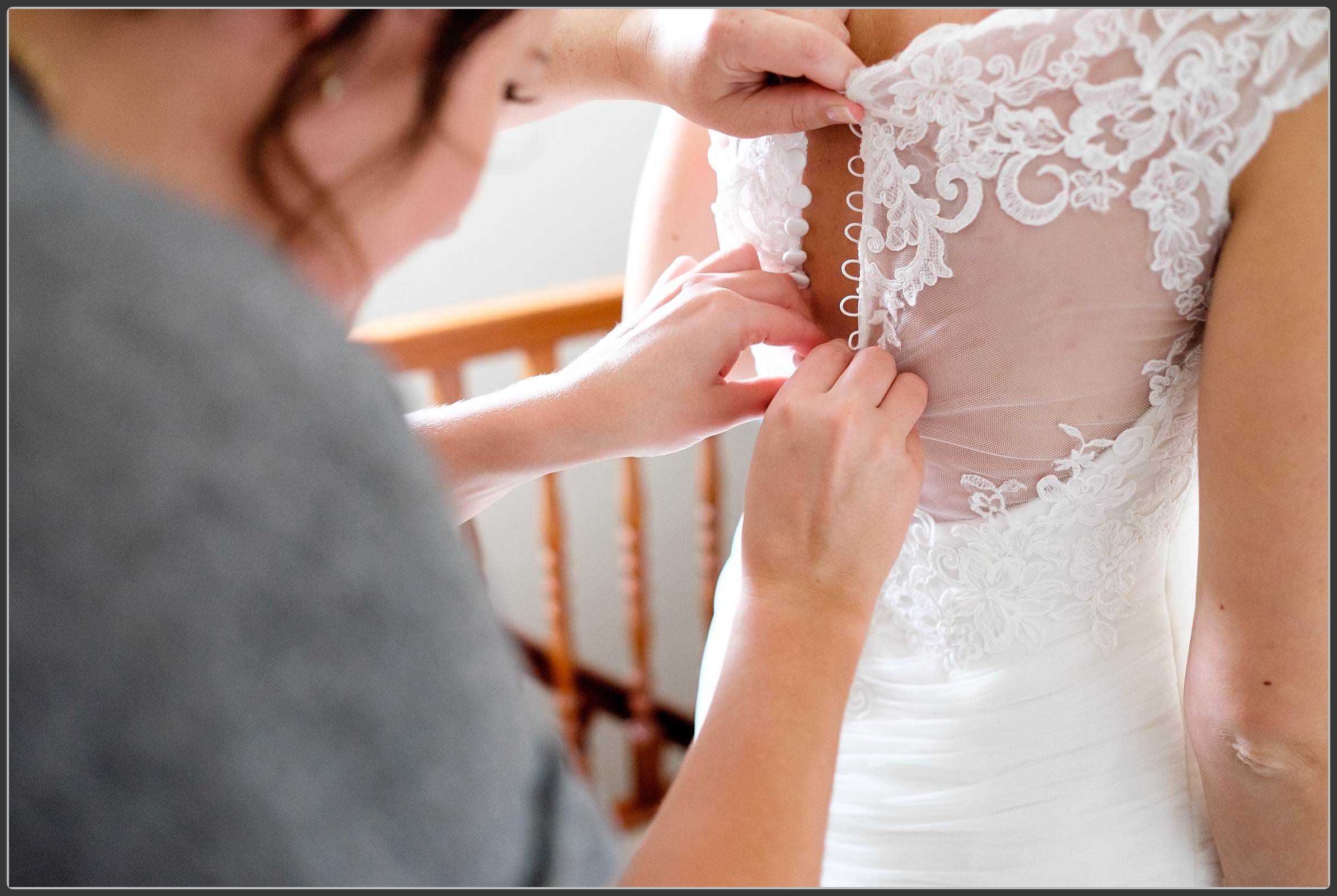 Bride having her dress done up