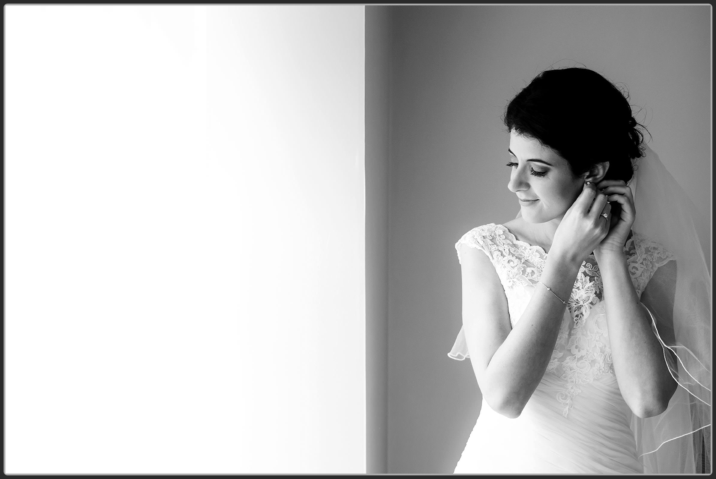 Bride putting on her earrings