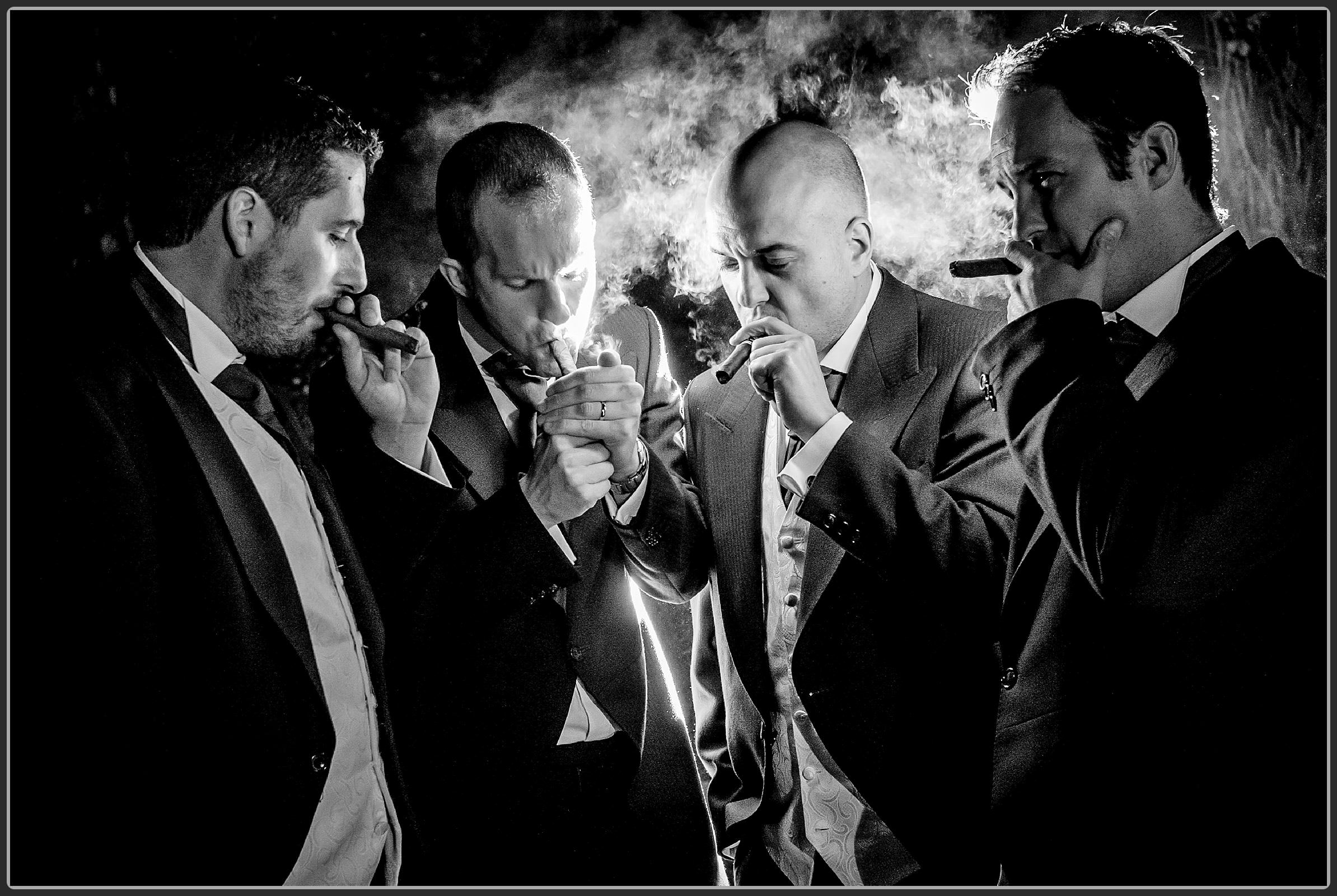 Groom and groomsmen having a cigar