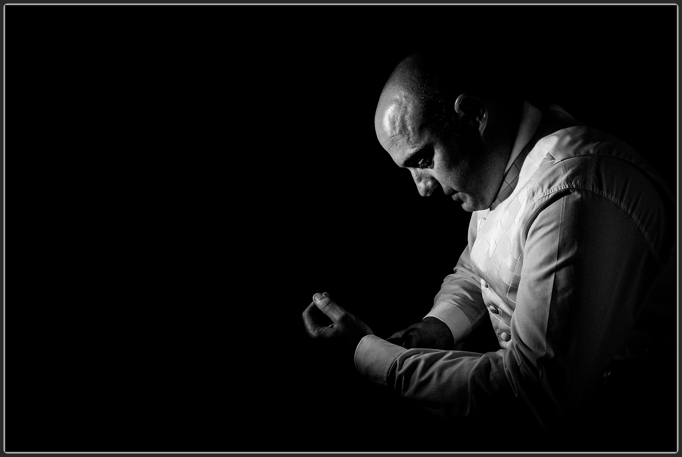 The groom adjusting his cuff links