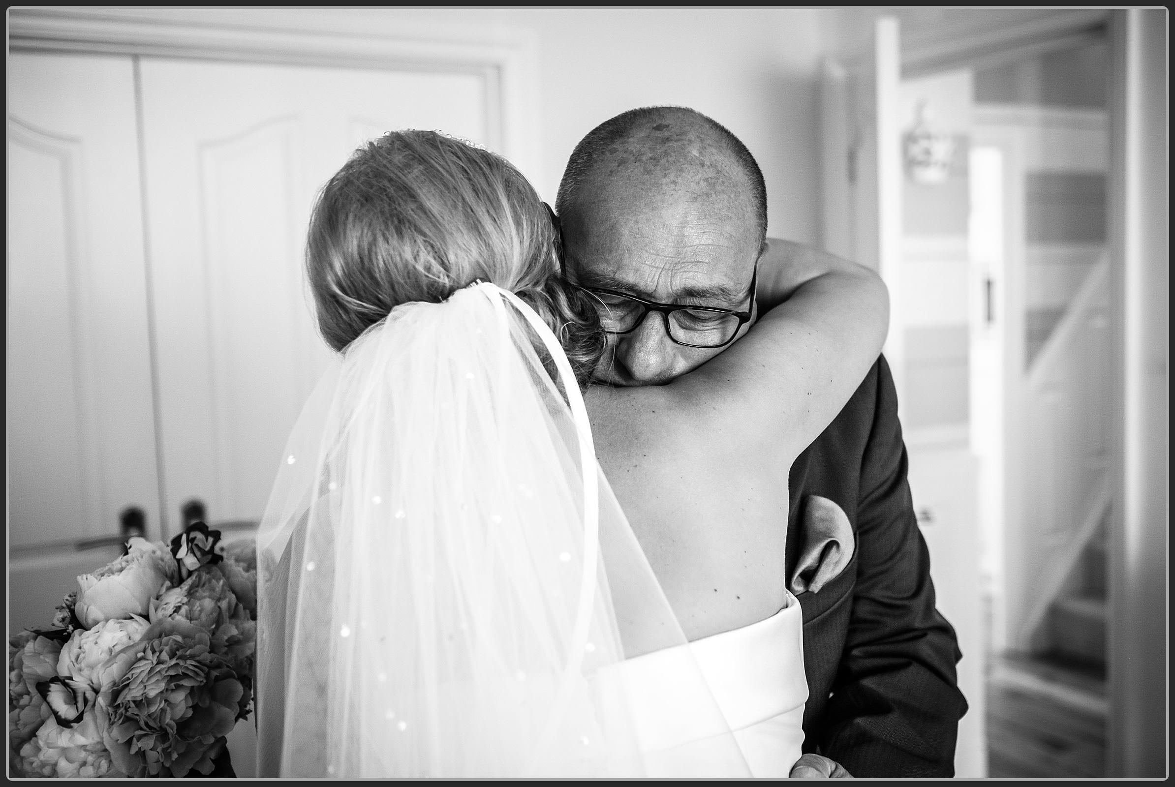 The brides father hugging her