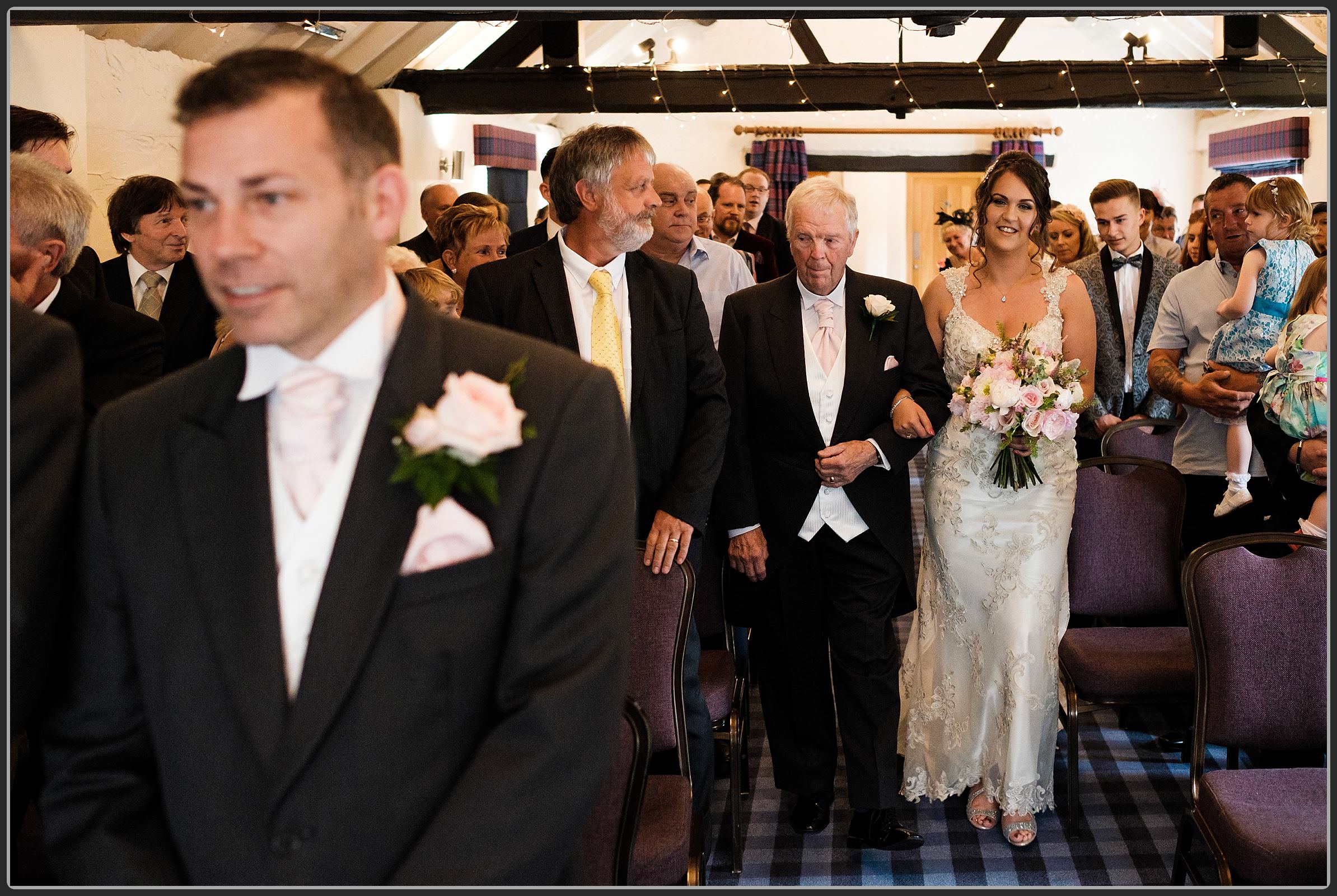 Bride walking down the aisle at the Windmill Village Hotel