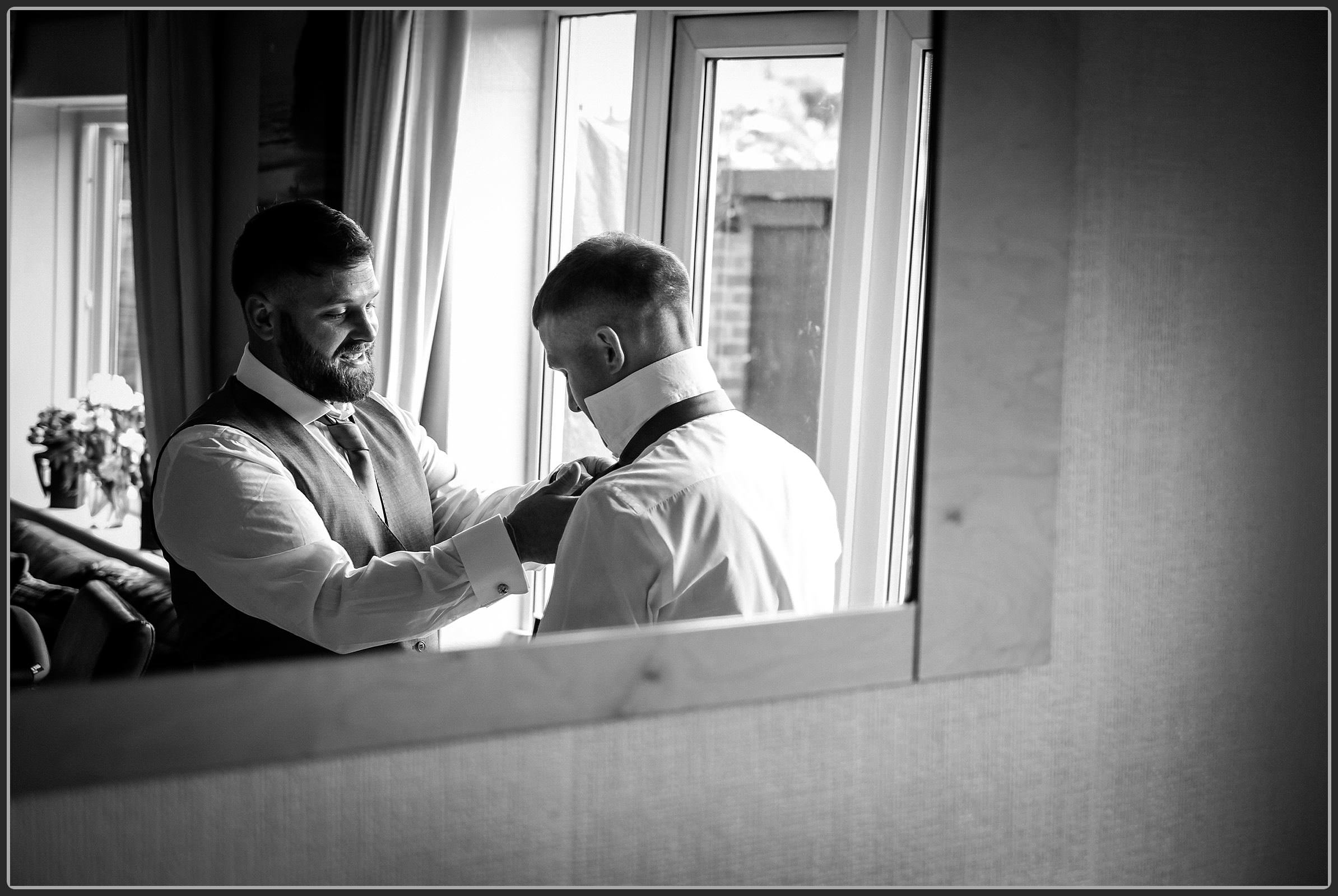 Best man helping the groom to get ready