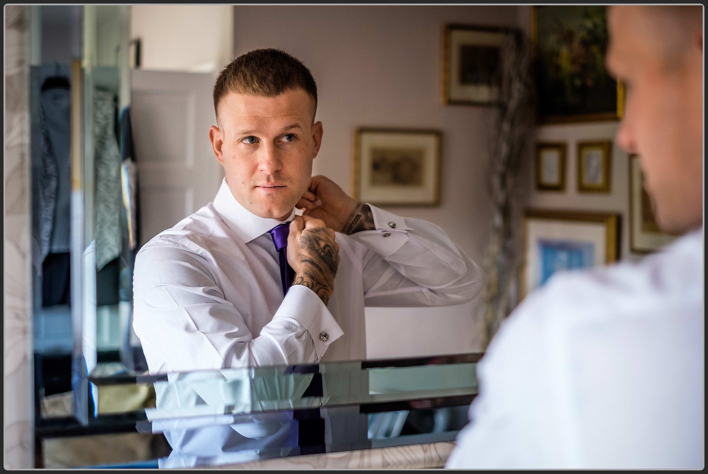 The groom adjusting his shirt