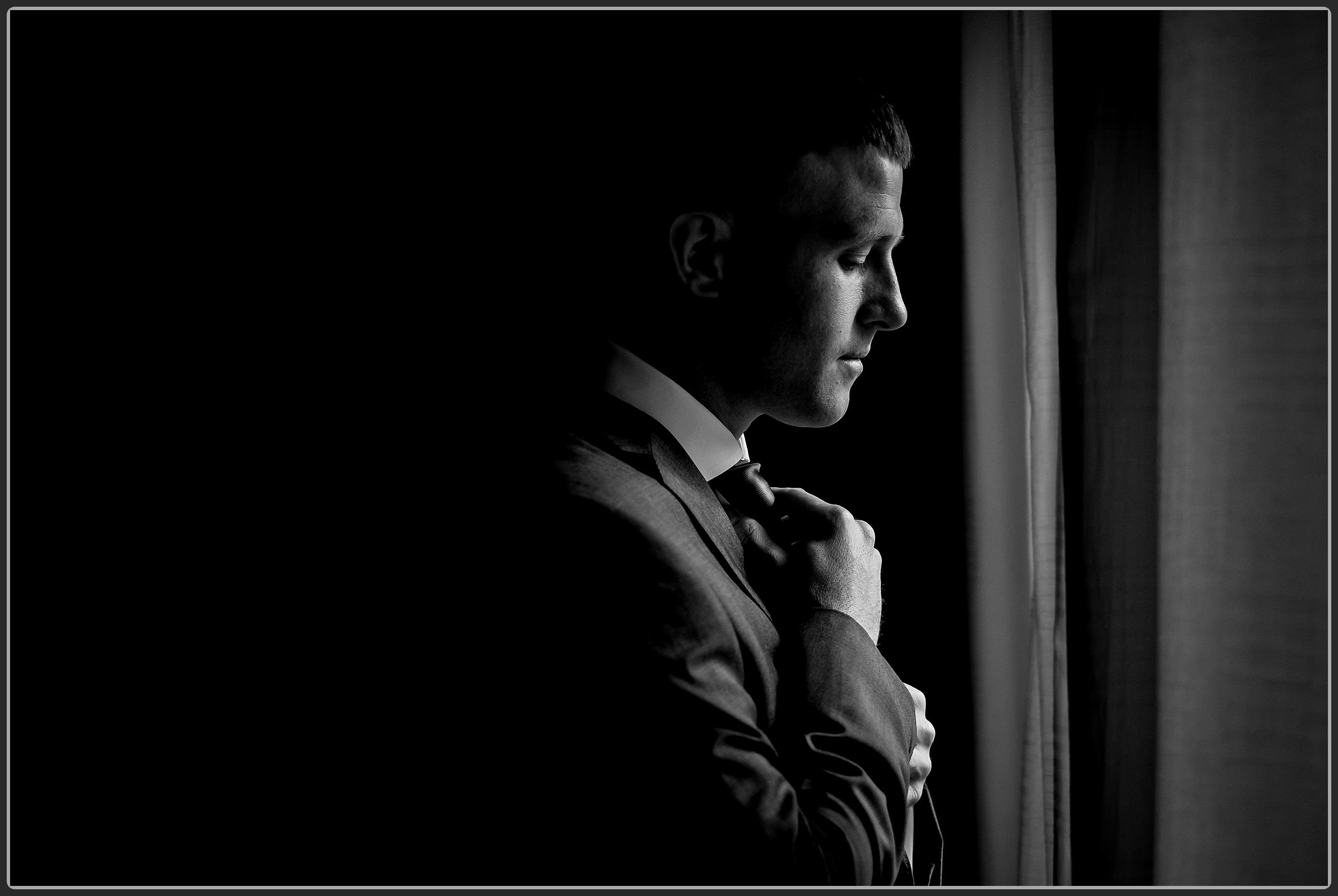 The groom adjusting his tie