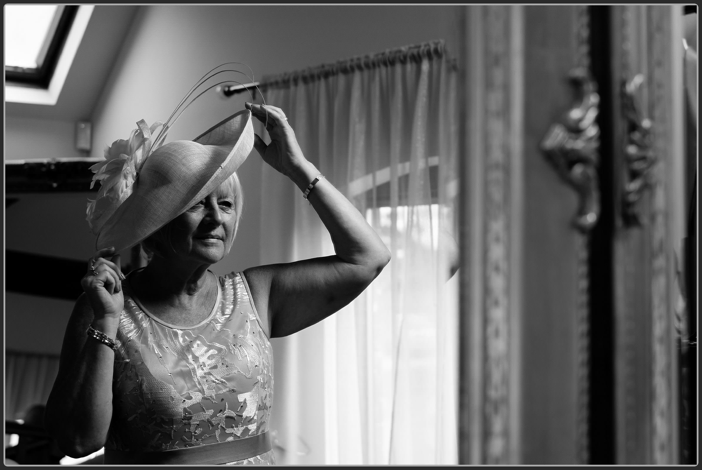 Brides mum adjusting her hat