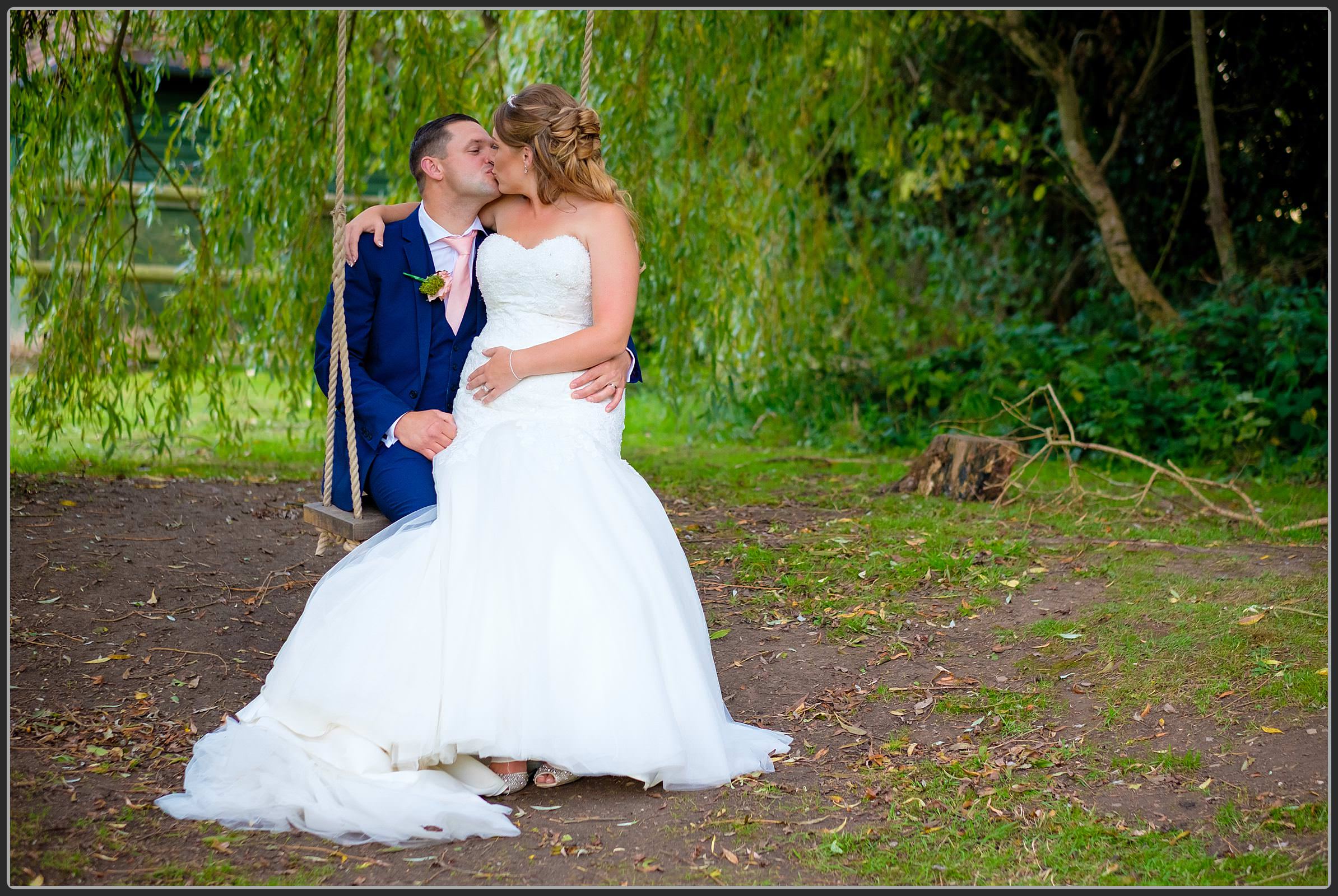 Bride and groom on the swing at Bordesley Park Farm