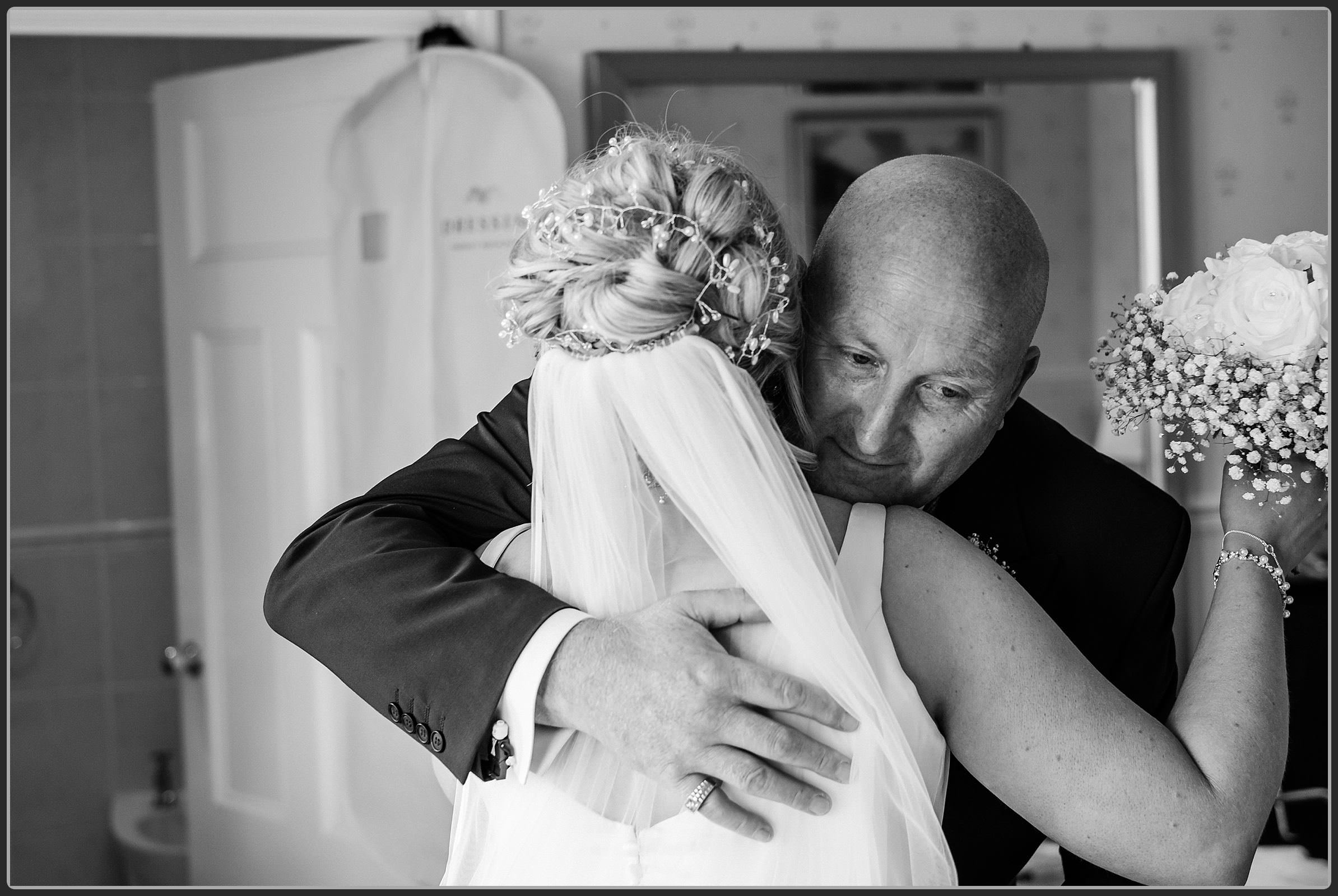 Brides father hugging his daughter