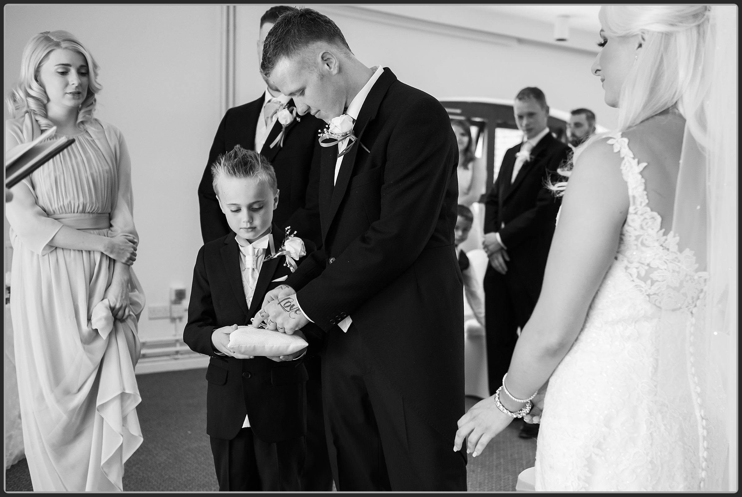 Page boy handing over the wedding rings