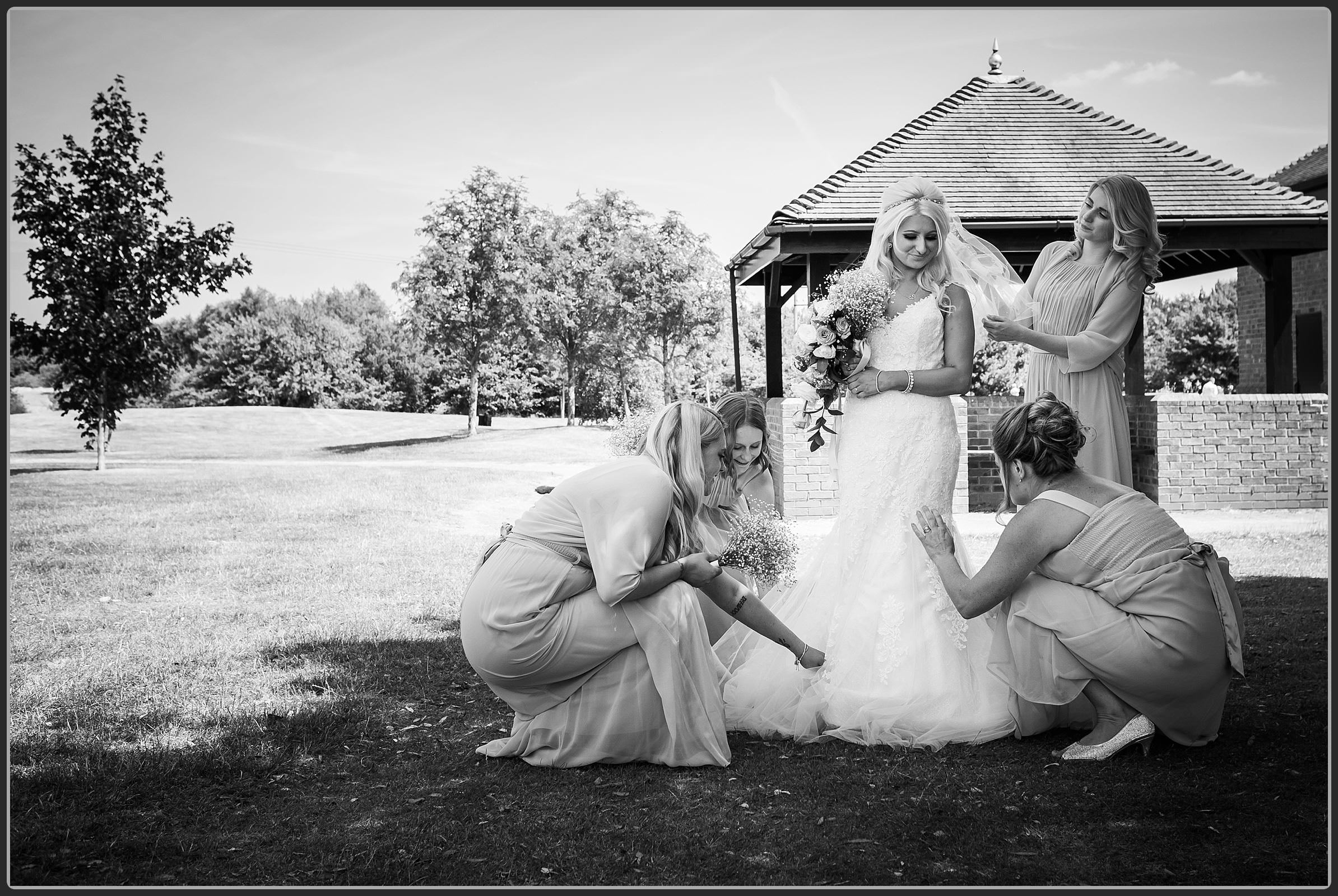 Bride and her bridesmaids altering the dress