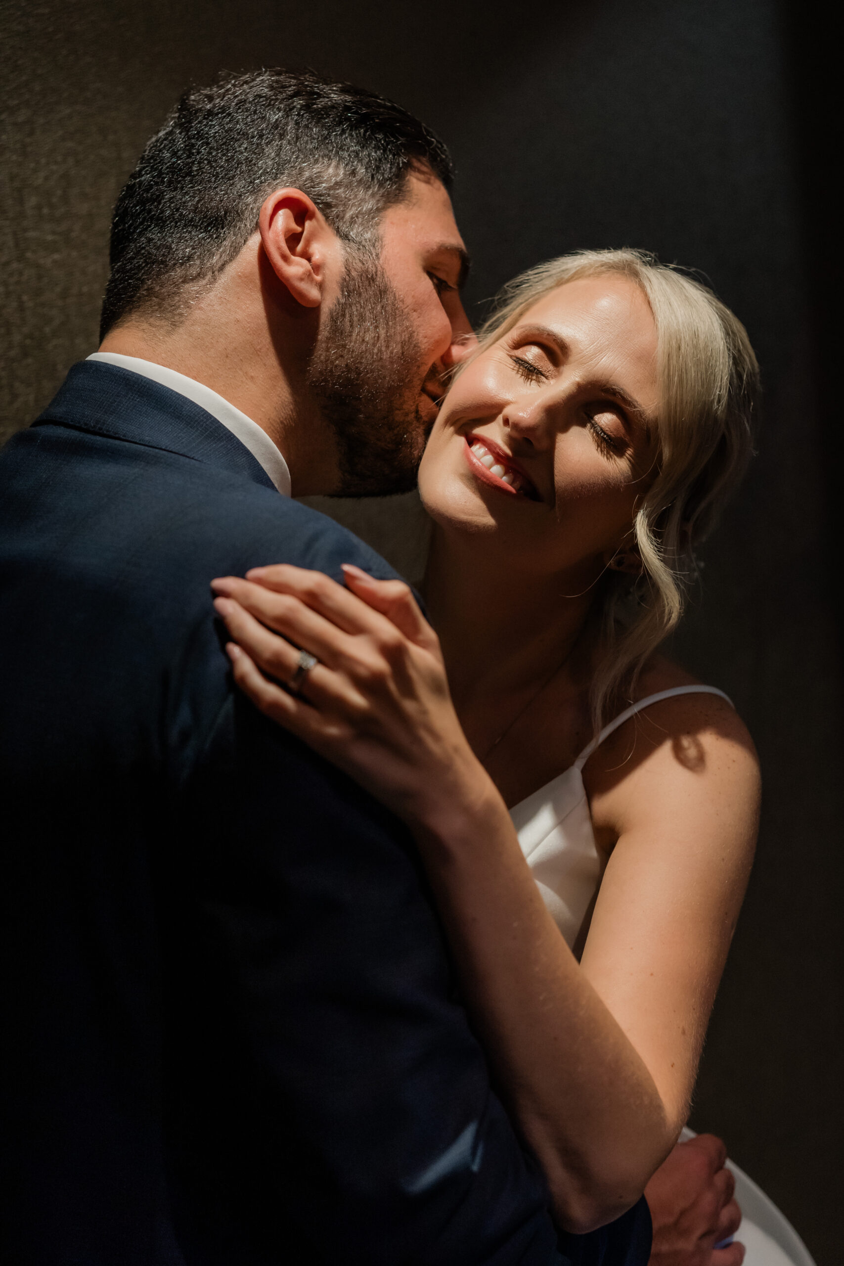 Bride and Groom embracing under a spot light