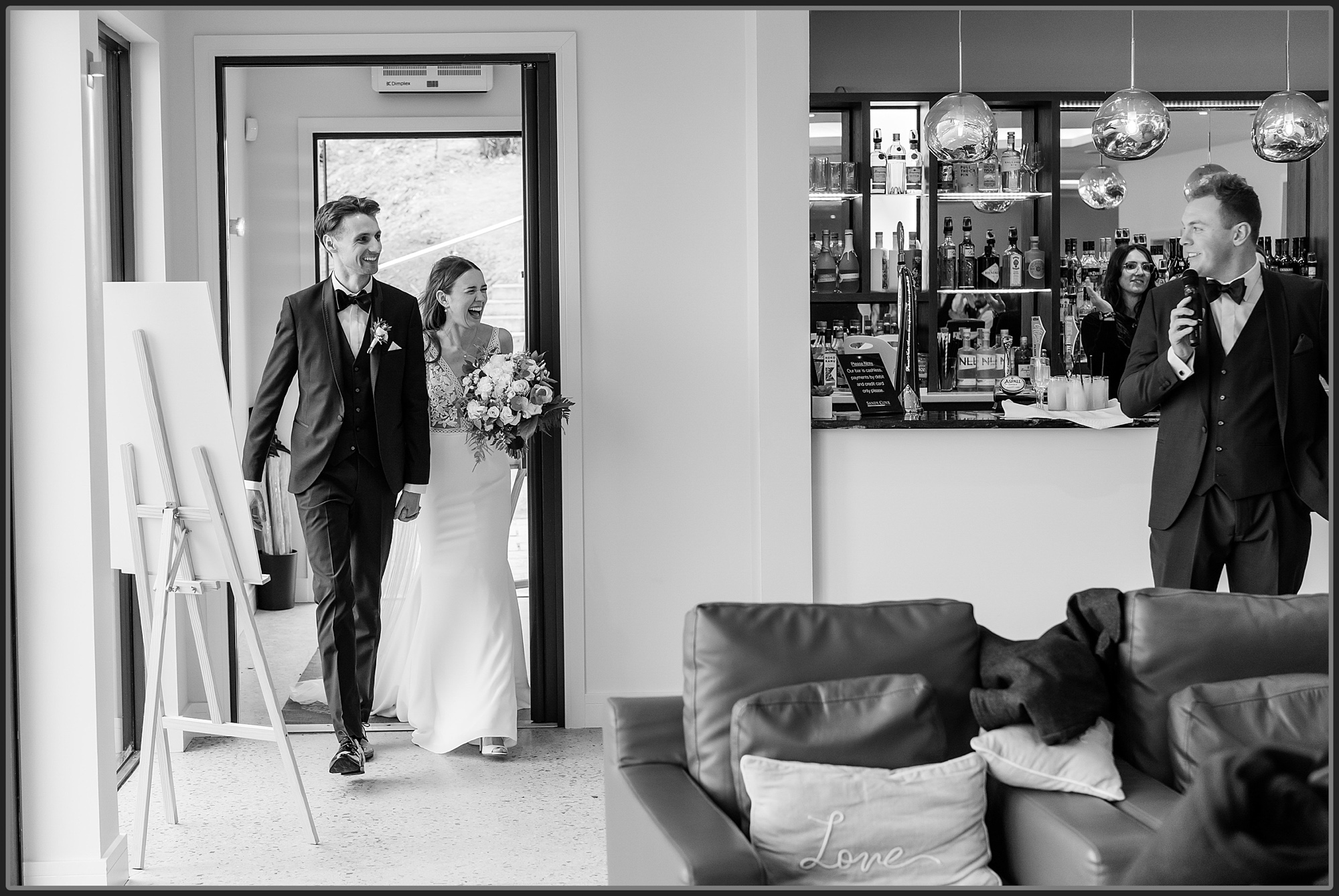 Bride and groom walking into their wedding breakfast