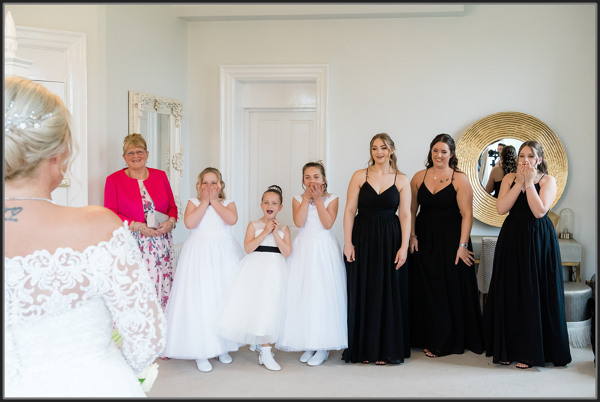 Bridesmaids seeing the bride for the first time in her wedding dress at Bourton Hall