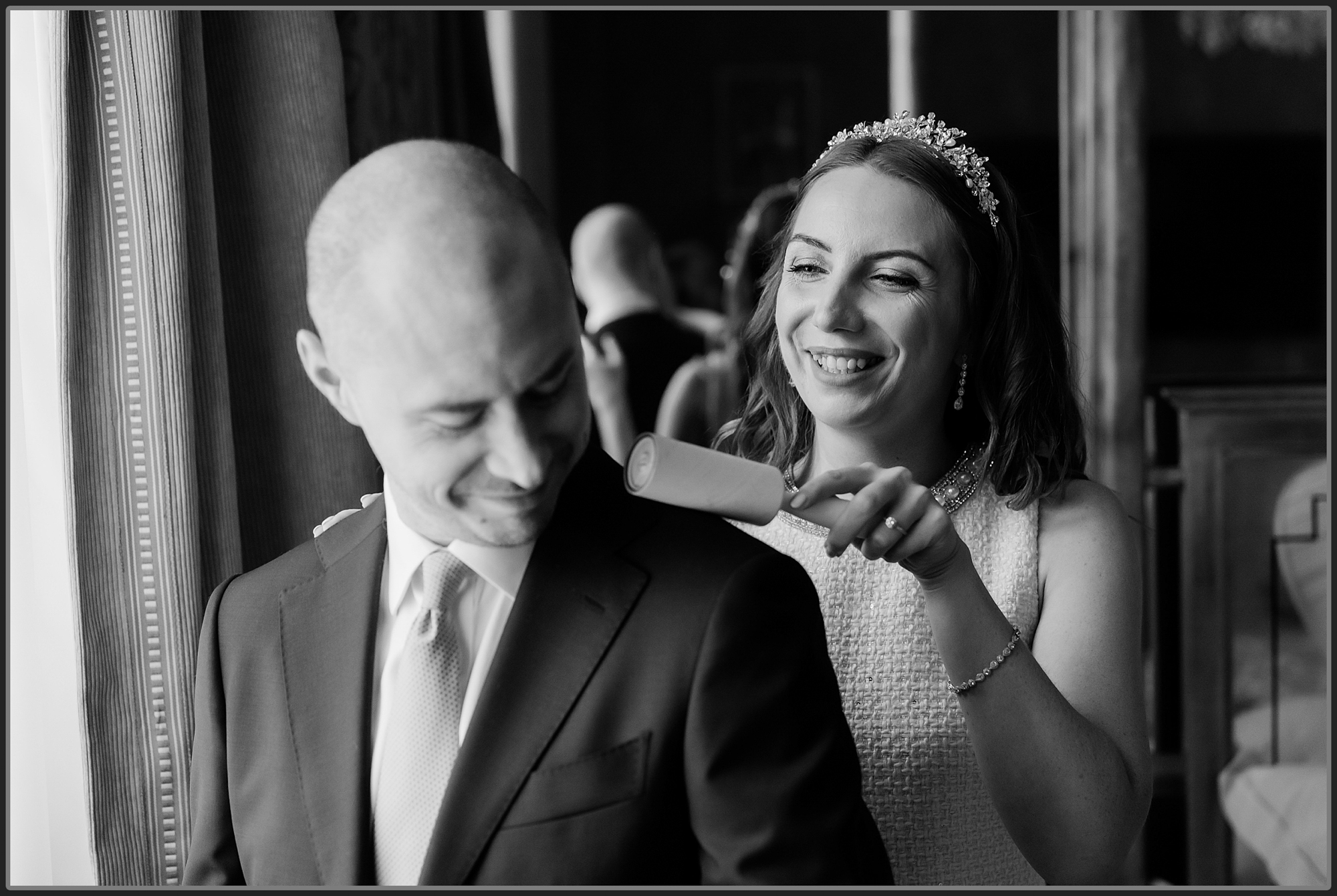 The bride cleaning the grooms jacket